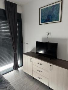a living room with a flat screen tv on a dresser at Stanisicguesthouse in Stanišiči