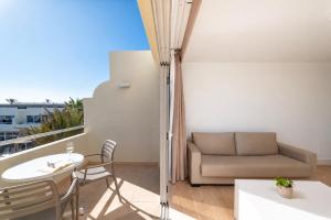 a balcony with a couch and a table and chairs at Hotel Arena Suite - Adults Only in Corralejo