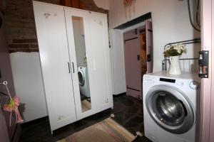 a laundry room with a washing machine and a washer at Casinha das Portas Amarelas in Monsaraz