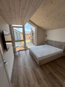 a bedroom with a bed and a large window at Kotedžas su baseinu ir pirtimi in Palanga +4 photos