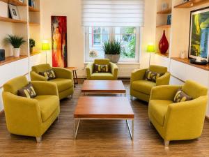 a waiting room with yellow chairs and a table at FlexInn Hotel Gelsenkirchen in Gelsenkirchen