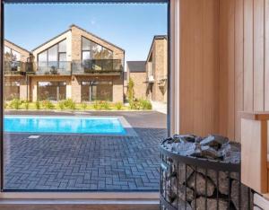 an open door to a house with a swimming pool at Kotedžas su baseinu ir pirtimi in Palanga