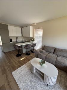 a living room with a couch and a table at Kotedžas su baseinu ir pirtimi in Palanga