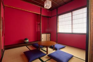 a room with a table and blue cushions in it at Kanazawa Machiya Kasaichi - Entire House Free Parking in Kanazawa +38 photos