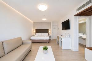 a hotel room with a bed and a couch at Hotel Arena Suite - Adults Only in Corralejo