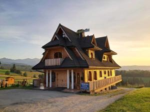 a large wooden house with a gambrel roof at Dom Wczasowy U Góralki in Murzasichle