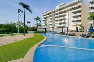a swimming pool in front of a building at Explore Nature & Beaches! Nuevo Nayarit Condo in Nuevo Nayarit