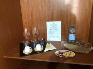 a table with glasses and a plate of food and a bottle of water at Donna Teresa in Castelbuono