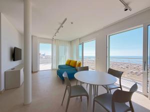 a living room with a blue couch and a table with chairs at Hotel Royal Garnì in Caorle