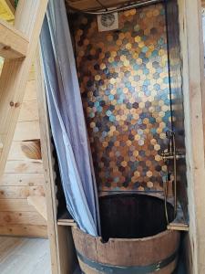 a bath tub with a shower curtain in a room at Tiny house a la ferme in Huelgoat