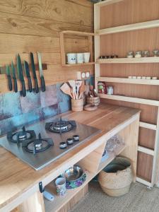a kitchen with a stove and some wooden cabinets at Tiny house a la ferme in Huelgoat