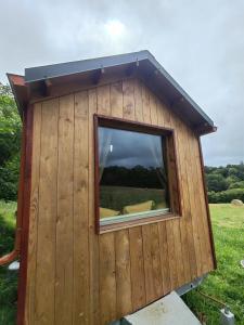 a building with a window in a field at Tiny house a la ferme in Huelgoat +5 photos