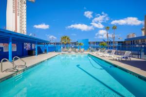 a swimming pool with chairs and a building at Travelsuites Hotel in Las Vegas