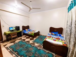a bedroom with a bed and a desk with a laptop at The Blue House in Safaga