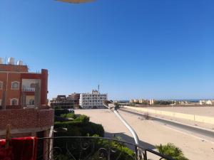 a balcony with a view of a beach and buildings at The Blue House in Safaga +5 photos