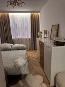 a bedroom with a bed and a dresser with a mirror at Apartament Piękna in Łomża