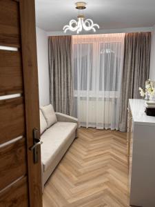 a living room with a couch in front of a window at Apartament Piękna in Łomża