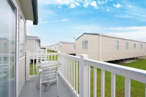 a balcony with a chair and a house at Cockerham Sands Holiday Park in Cockerham