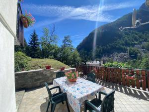 a table and chairs on a patio with a view at Maison au Soleil in Valtournenche