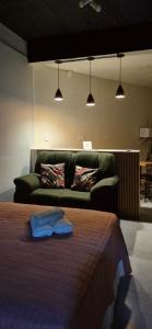 a bedroom with a bed and a couch and lights at Aconchego I - Centro in Miguel Pereira