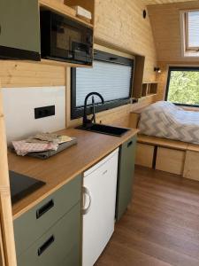 a kitchen in a tiny house with a bed at Tiny House Luc in Prato Carnico