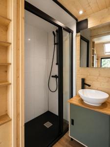 a bathroom with a glass shower with a sink at Tiny House Luc in Prato Carnico