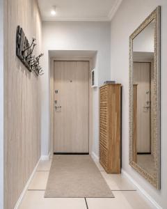 a hallway with a door and a mirror at Stylish air-conditioned Klaipeda Flat, Near Dane River in Klaipėda