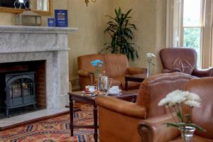 a living room with two chairs and a fireplace at B/W Plus Buxton Lee Wood Hotel in Buxton