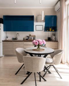 a kitchen with a table with pink flowers on it at Stylish air-conditioned Klaipeda Flat, Near Dane River in Klaipėda +3 photos
