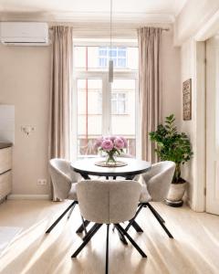 a dining room with a table and chairs and a window at Stylish air-conditioned Klaipeda Flat, Near Dane River in Klaipėda