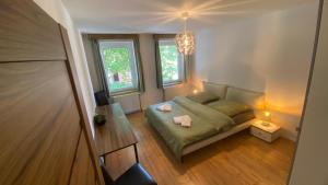 a small bedroom with a bed and two windows at Wunderhaus am Goitzschesee in Bitterfeld