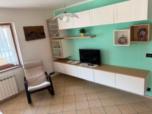 a room with a desk with a television and a chair at Casa Ilaria in Campolongo