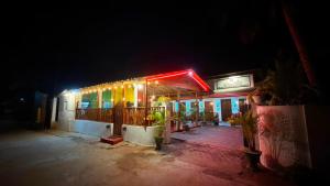 a building with a neon sign on it at night at Coral Moon in Trincomalee