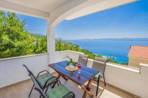 a table and chairs on a balcony with a view of the ocean at White Cove Apartments in Lokva Rogoznica +56 photos