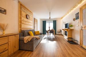a living room with a couch and a table at Apartamenty pod Góralskim Niebem in Gliczarów Górny