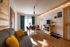 a living room with a couch and a table at Apartamenty pod Góralskim Niebem in Gliczarów Górny