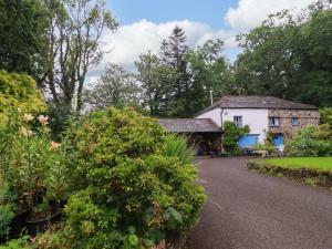 an old house with a garden in front of it at The Water Mill at Boyton Mill in Launceston