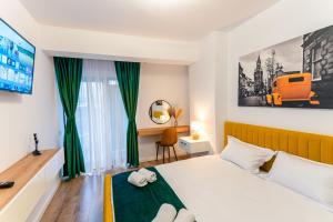 a bedroom with a white bed and green curtains at Apartament23 Sibiu in Şelimbăr