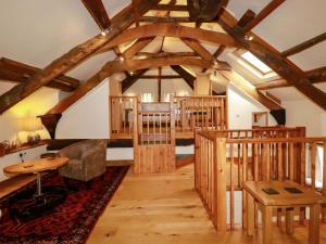 a living room with wooden beams and a room with a table at The Water Mill at Boyton Mill in Launceston