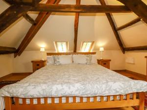 a bedroom with a large bed with wooden beams at The Water Mill at Boyton Mill in Launceston