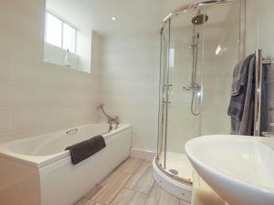 a bathroom with a tub and a sink and a shower at The Water Mill at Boyton Mill in Launceston +19 photos