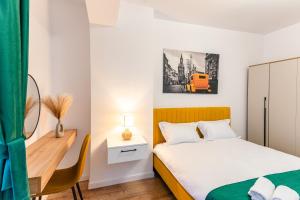 a small bedroom with a bed and a desk at Apartament23 Sibiu in Şelimbăr
