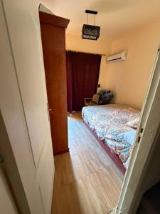 a small bedroom with a bed and a door at Tahiti North coast in Al Ḩammām +8 photos