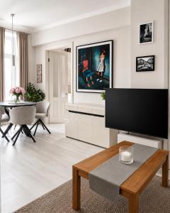 a living room with a flat screen tv and a table at Stylish air-conditioned Klaipeda Flat, Near Dane River in Klaipėda