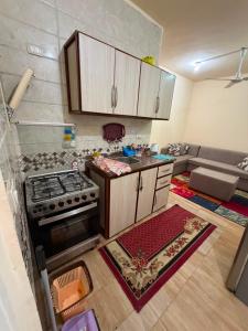 a kitchen with a stove and a couch in a room at Tahiti North coast in Al Ḩammām