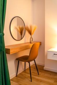a mirror and a chair in a room at Apartament23 Sibiu in Şelimbăr