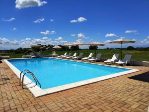 a swimming pool with chairs and umbrellas at Cascina Benotto in Moriondo Torinese