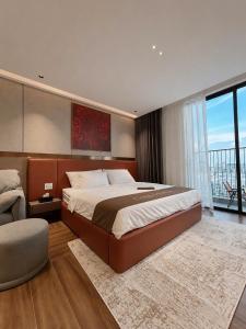 a large bedroom with a large bed and a chair at The Pathway Sầm Sơn in Sầm Sơn
