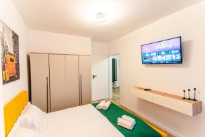 a bedroom with a bed and a tv on the wall at Apartament23 Sibiu in Şelimbăr +24 photos