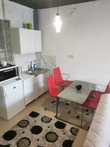 a kitchen with red chairs and a table and a counter at PRISHTINA Stay in Prishtinë